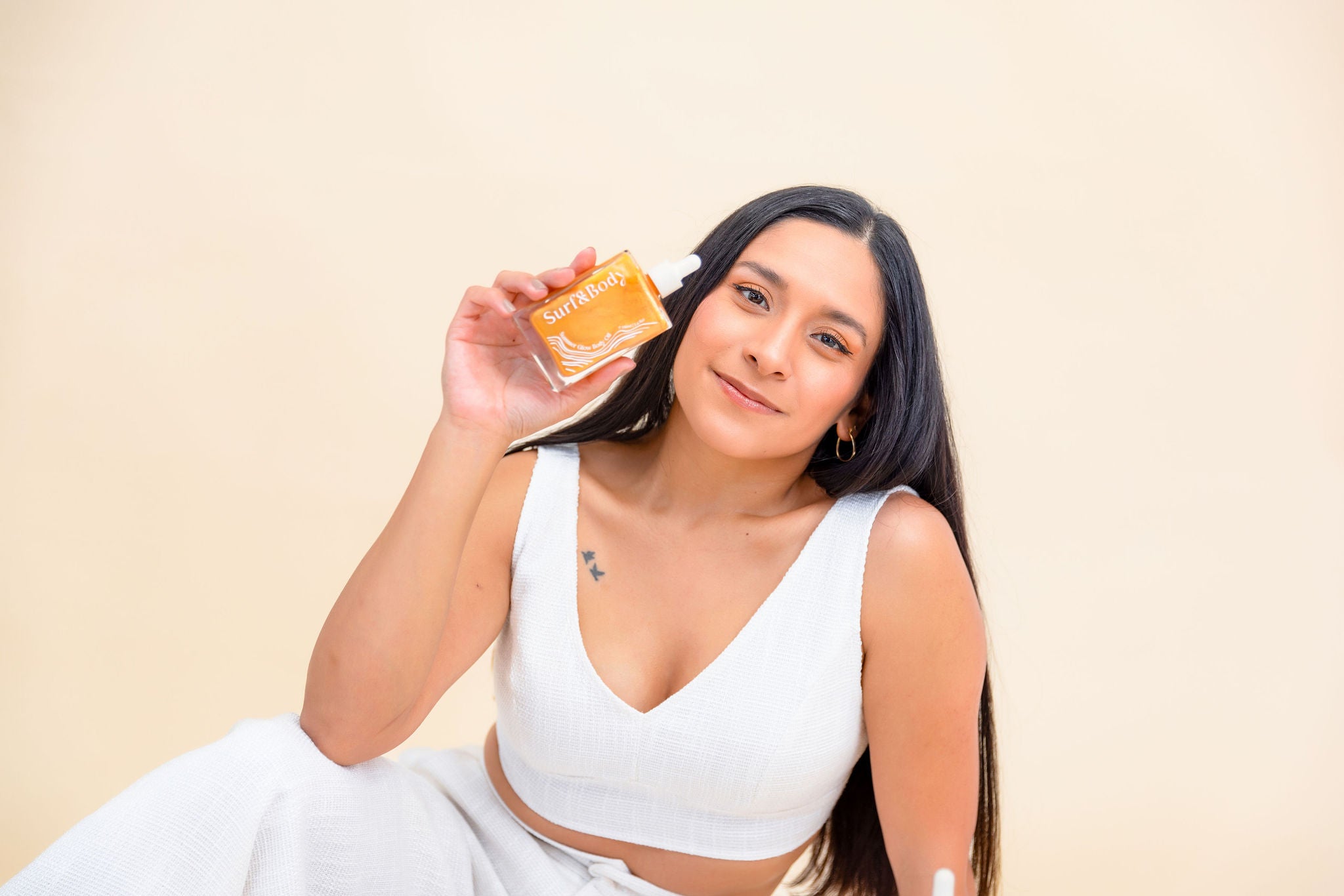 woman business owner, holding a body shimmer, beauty brand, beauty product photography