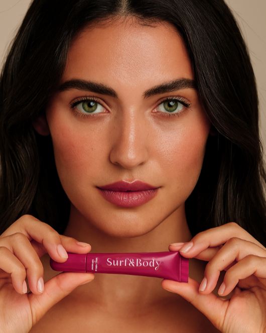 Woman holding a peptide lip gloss in berry colour. Peptide lip tint in berry colour named Rebel. 